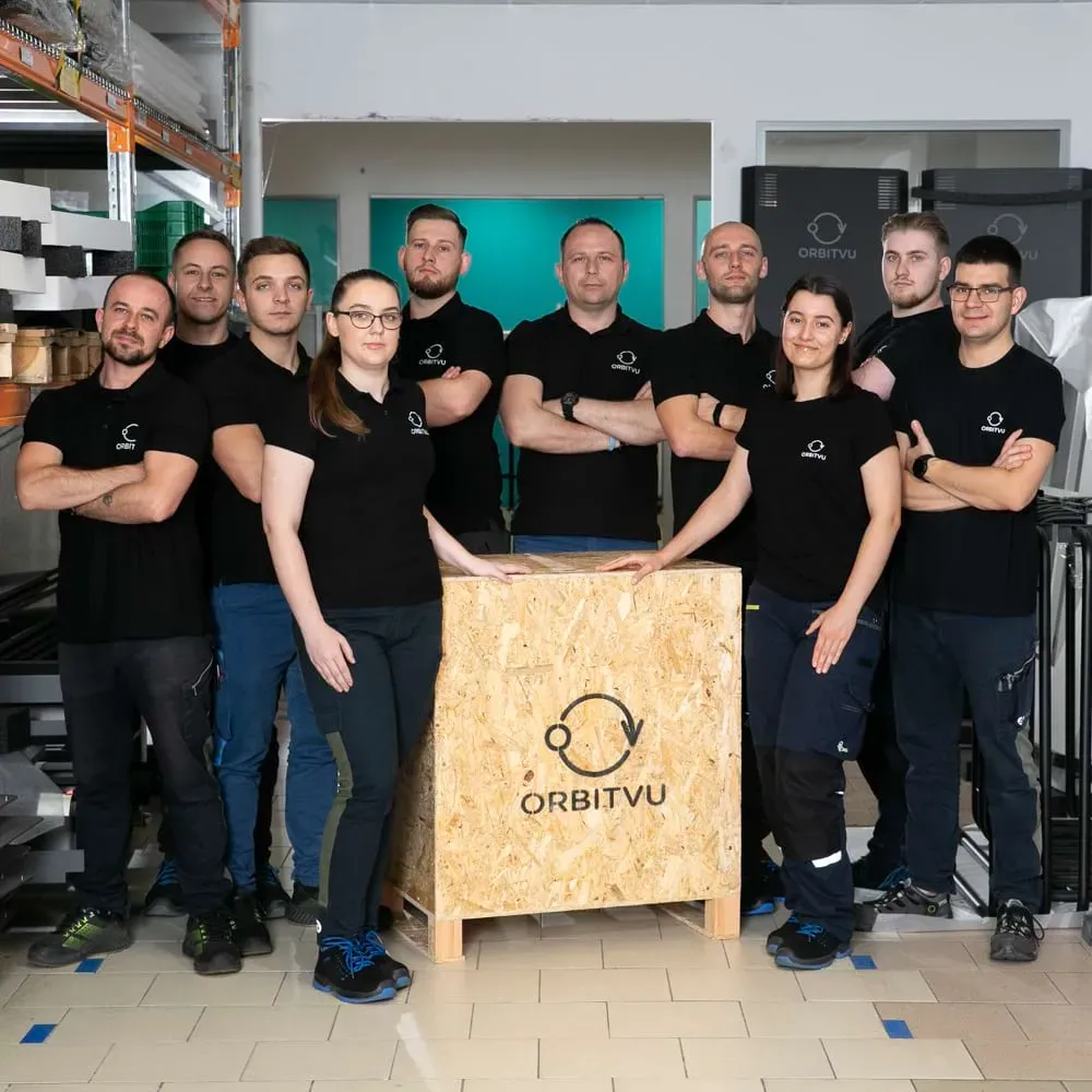 Equipo de producción y logística de Orbitvu posando con una caja de madera de la marca