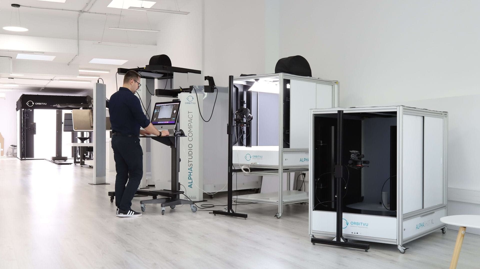 Operador de estudio e-commerce trabajando con máquinas de fotografía de producto Orbitvu