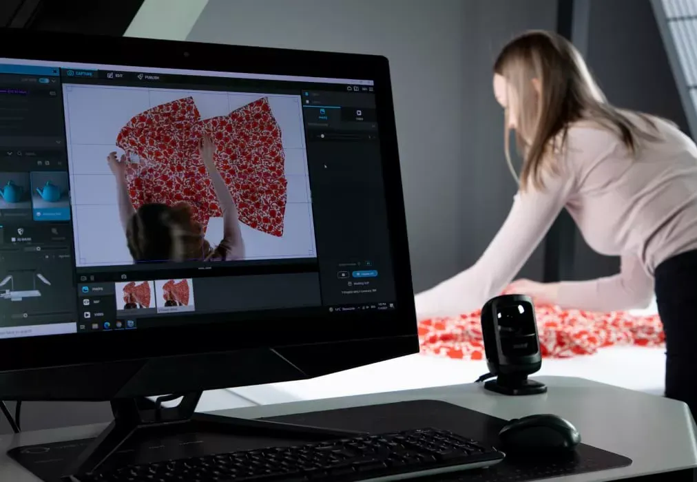 Fotógrafo ajustando una prenda de tejido floral con vista en directo en el monitor
