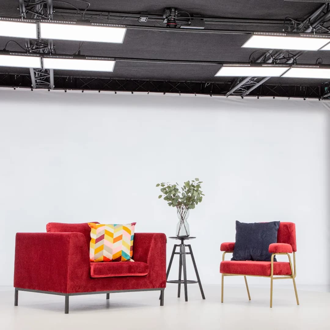Sillones rojos modernos y mesa auxiliar en un estudio fotográfico profesional