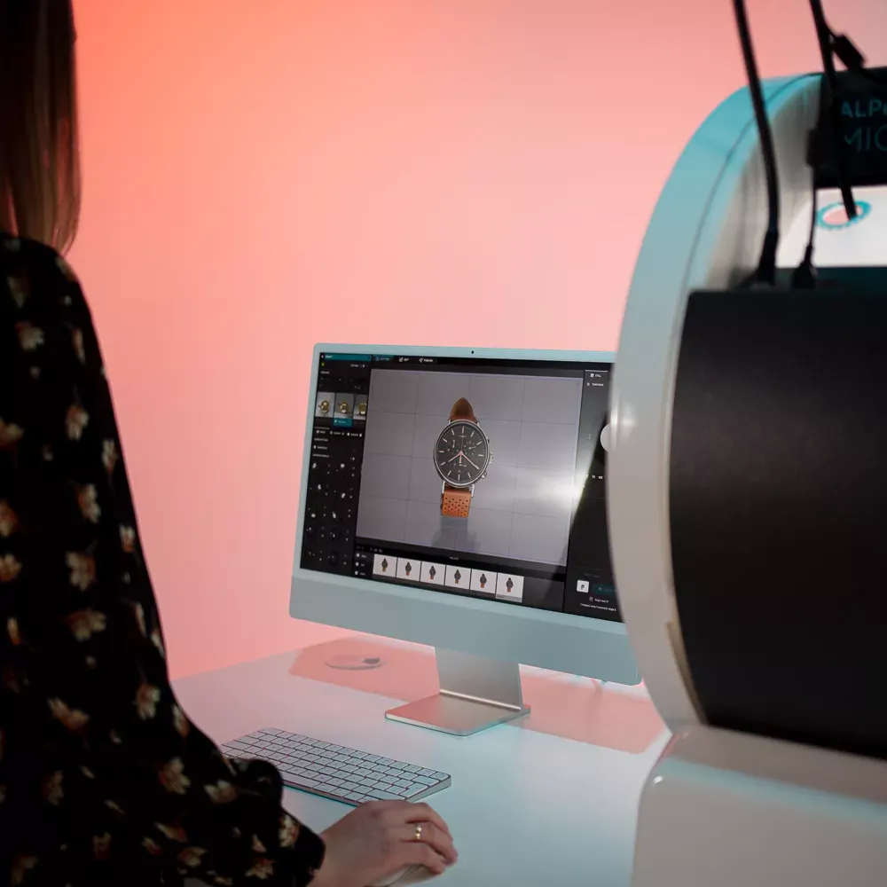 Mujer fotografiando un reloj con interfaz de software en el ordenador