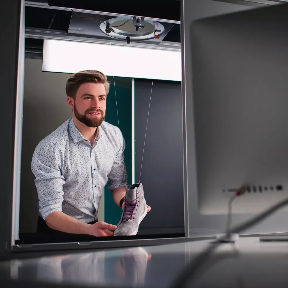 Hombre preparando un producto para una fotografía profesional de calzado