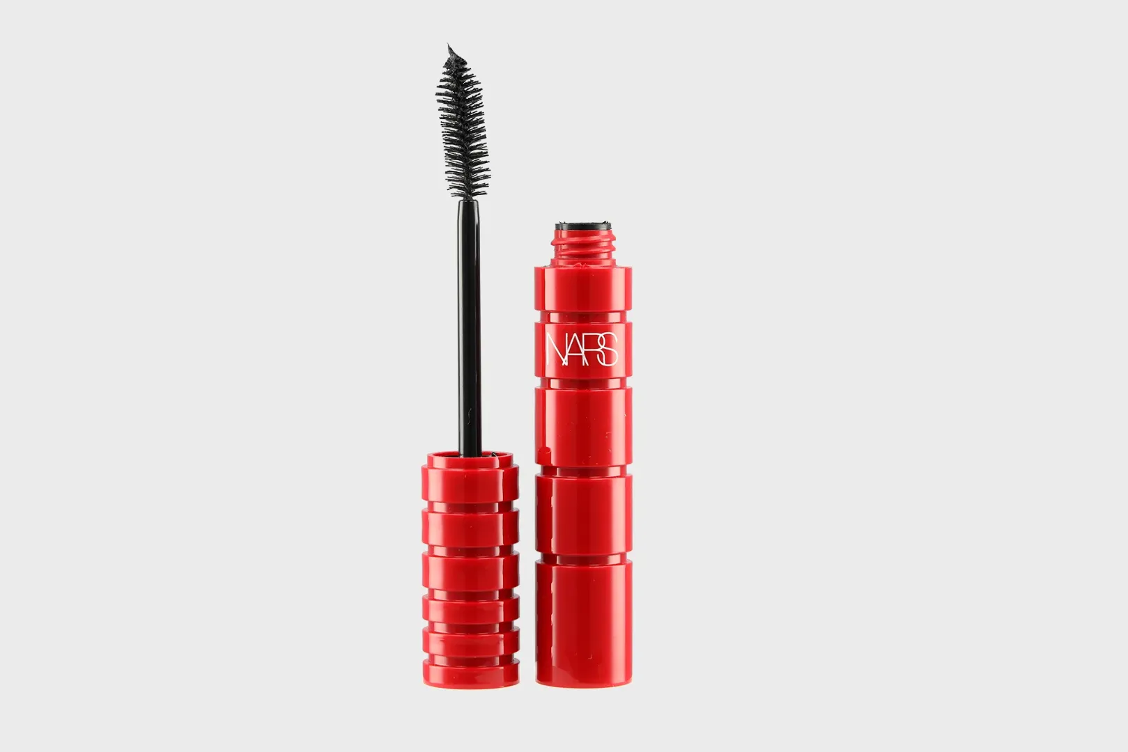 Bodegón de tubo rojo y cepillo de máscara NARS Climax